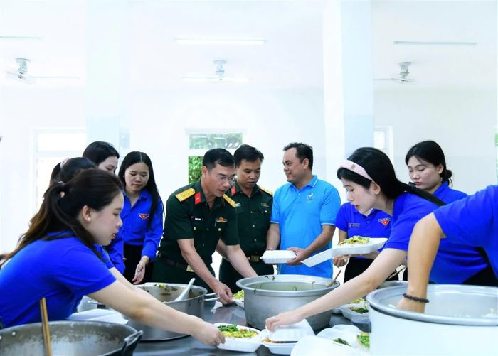 Các đơn vị phối hợp nấu cơm trưa miễn phí cho thí sinh dự thi tại điểm thi Trường THPT Hướng Phùng, xã Hướng Phùng - Ảnh: NVCC