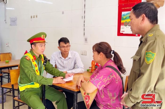 Lực lượng chức năng phường Mộc Sơn tuyên truyền các hộ kinh doanh không lấn chiếm và sử dụng trái phép hành lang an toàn giao thông.