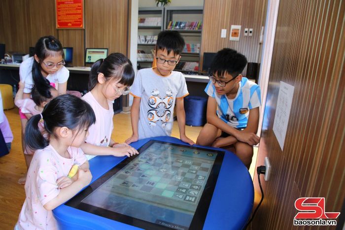 Các em nhỏ trải nghiệm chơi cờ vua trên màn hình tương tác thông minh.