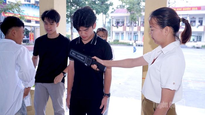 Lực lượng coi thi kiểm tra kim loại trước khi thí sinh vào phòng thi tại điểm thi trường THPT Quản Bạ. Ảnh: Bang Phúc