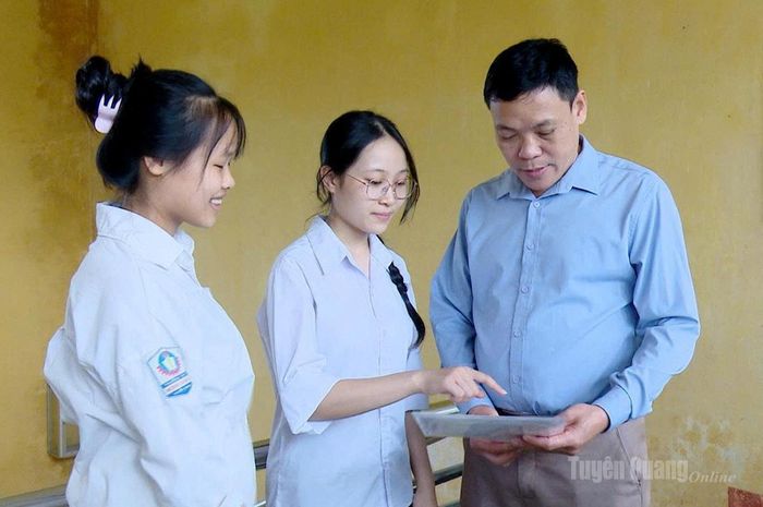 Thầy giáo Trần Minh Cương, Hiệu trưởng trường THPT Minh Quang, cùng thí sinh xem lại đề thi sau khi hoàn thành bài thi môn Ngữ Văn. Ảnh: Minh Hoa