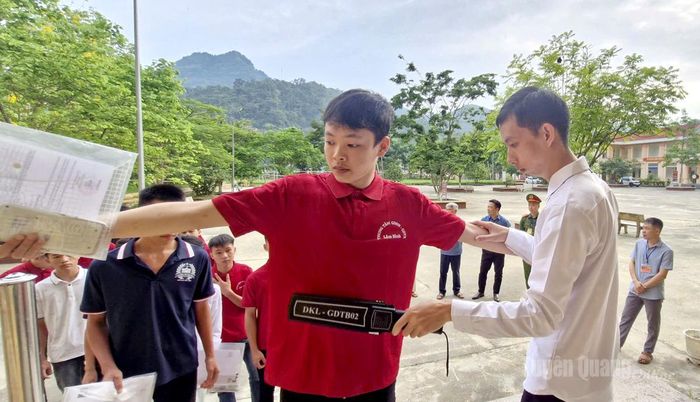 Lực lượng coi thi kiểm tra kim loại trước khi thi sinh vào phòng thi tại điểm thi trường THPT Lâm Bình. Ảnh Minh Hoa