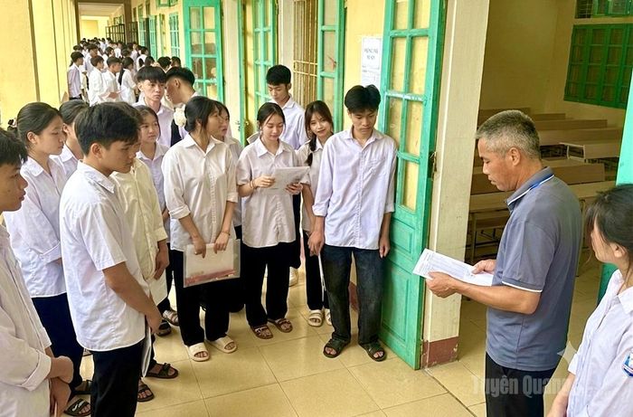 Cán bộ coi thi trường THCS và THPT Kháng Nhật kiểm tra, đối chiếu thông tin thí sinh trước khi vào phòng thi. Ảnh: Khánh Trang