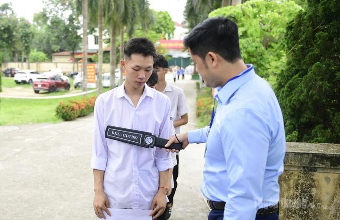 Cán bộ tại điểm thi Trường THPT Xuân Huy kiểm tra an ninh đối với các thí sinh dự thi chiều nay. Ảnh Quốc Việt