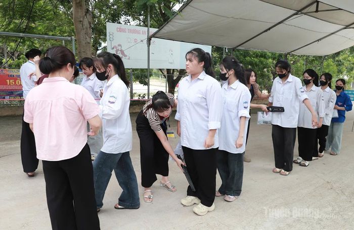 Kiểm tra thiết bị điện tử của thí sinh trước khi vào thi tại điểm thi trường THPT Kim Xuyên. Ảnh: Phi Anh