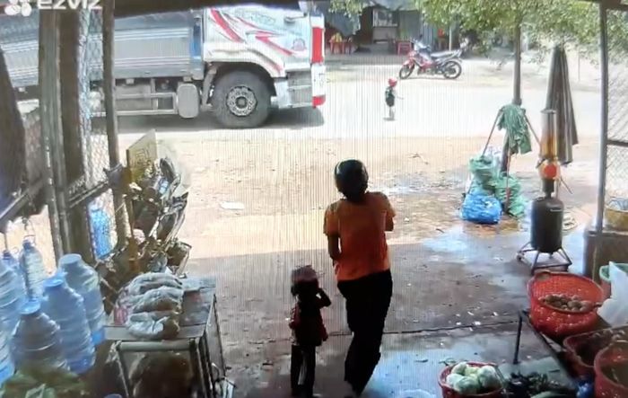 Thời điểm cháu bé chạy qua đường và bị xe tải cán tử vong. (Ảnh cắt từ clip)