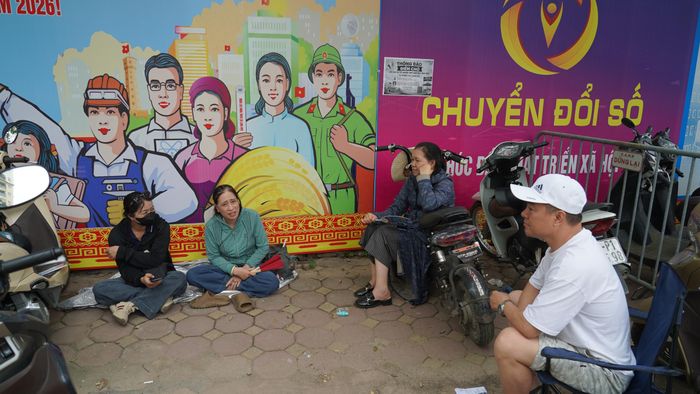 Ngoài cổng trường, những phụ huynh lặng lẽ chờ đợi, cùng nhau chia sẻ những câu chuyện thi cử và niềm tin vào các thí sinh.