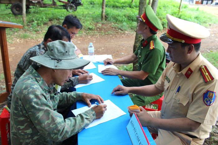 Lực lượng CSGT tổ chức cho người dân ký cam kết chấp hành các quy định về trật tự, an toàn giao thông đối với người điều khiển xe máy kéo nhỏ.
