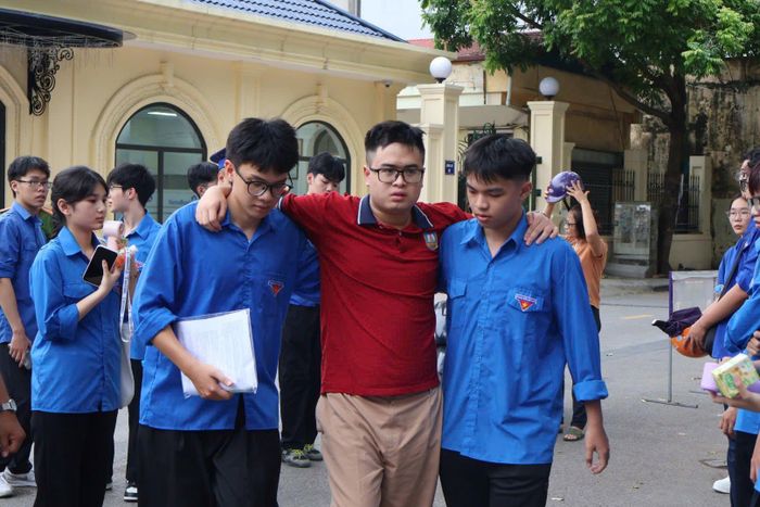 Thí sinh bị đau chân được lực lượng tình nguyện hỗ trợ dìu vào điểm thi trong ngày thi đầu tiên.