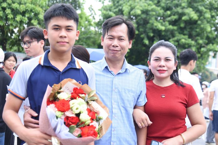 Một gia đình tặng hoa chúc mừng con ngay sau khi kết thúc môn thi Ngữ văn đầu tiên tại điểm thi Trường THCS Tây Mỗ (phường Từ Liêm). Ảnh: Xuân Quý