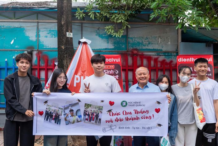 Gia đình mang băng rôn chúc mừng thí sinh hoàn thành bài thi môn Toán tại điểm Trường THPT Lê Quý Đôn. Ảnh: Mạnh Hưng