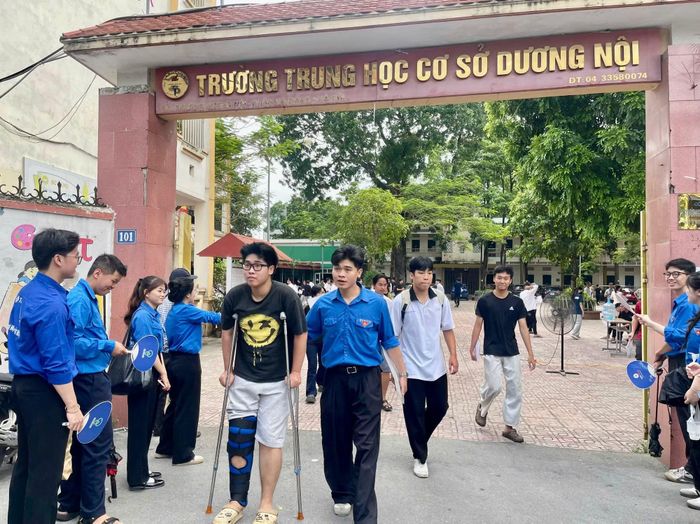 Em Nguyễn Ngọc Đại, học sinh Trường THPT Lê Quý Đôn bị chấn thương ở chân được các tình nguyện viên hỗ trợ vào phòng thi.