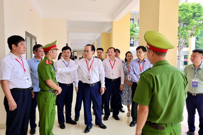 Bộ trưởng Bộ GD&ĐT Hoàng Minh Sơn trò chuyện với cán bộ Công an làm nhiệm vụ tại Điểm thi Trường THPT Kim Động, Hưng Yên.