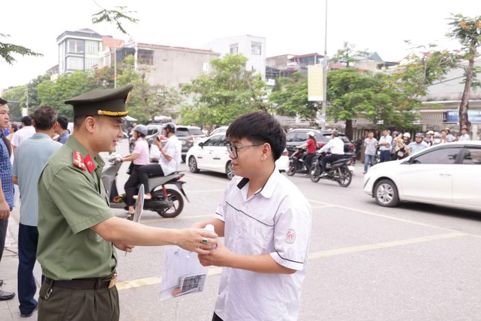 Chiến sĩ Công an tặng chai nước kèm lời chúc thí sinh làm bài tốt.