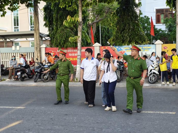 Đoàn viên thanh niên Công an tỉnh Khánh Hòa đưa thí sinh qua đường đảm bảo an toàn giao thông khi đến điểm thi.