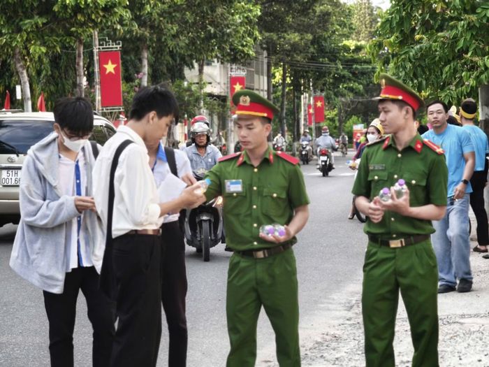 Đoàn viên thanh niên Công an tỉnh Khánh Hòa trao tặng nước uống cho thí sinh tại điểm thi ở phường Phan Rang.