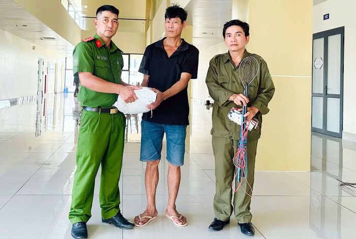 Cán bộ Công an phường Long Xuyên trao gạo tặng người dân tự nguyện giao nộp công cụ kích điện dùng để khai thác thủy sản.