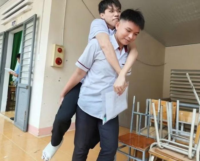 Thí sinh Hữu Tuấn Anh được bạn bè cõng đến phòng thi vì bị tai nạn.