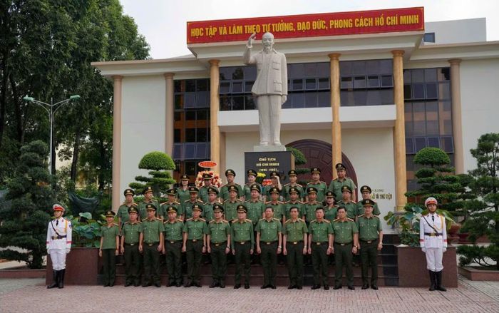 Đoàn công tác chụp ảnh lưu niệm tại Tượng đài Bác Hồ trong khuôn viên trường.