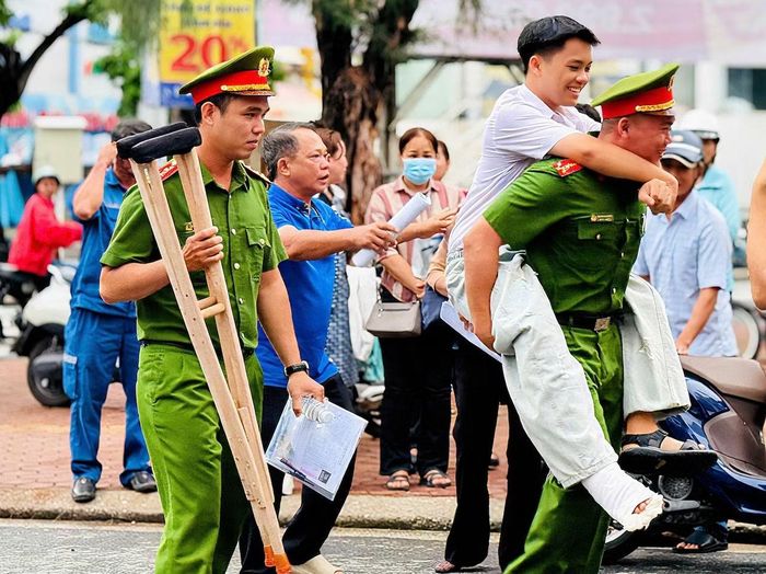 Cán bộ Công an trực tiếp hỗ trợ em Lê Đăng Khoa, đến phòng thi tại trường THPT Hồ Thị Kỷ an toàn.