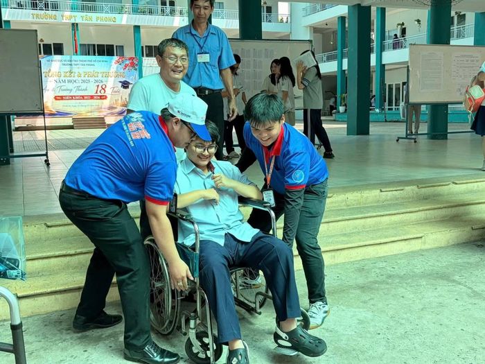 Các tình nguyện viên hỗ trợ thí sinh đi xe lăn tại điểm thi.