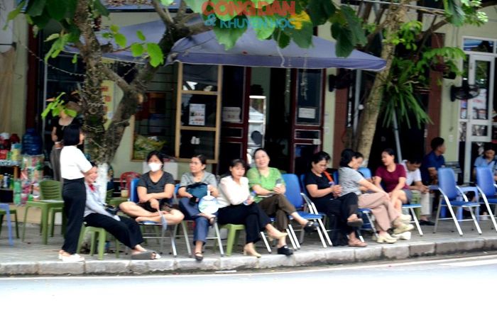 Phụ huynh học sinh chờ bên ngoài điểm thi. Ảnh: Quốc Hồng