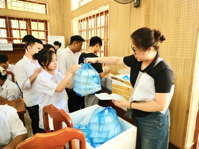 Học sinh tại điểm thi Trường THPT Thành phố nhận suất cơm miễn phí từ nguồn xã hội hóa.