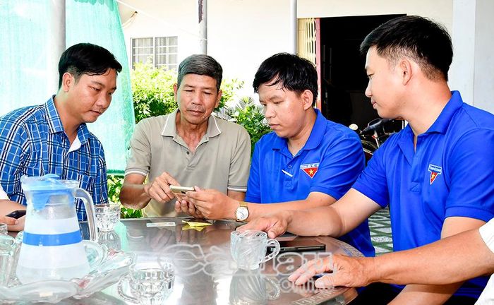 Thành viên tổ công nghệ số cộng đồng hướng dẫn người dân, hộ kinh doanh cài đặt và sử dụng các ứng dụng số.