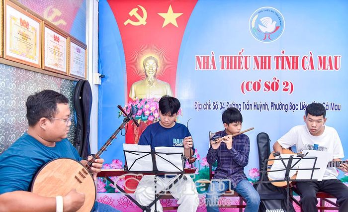 Em Trần Hoàng Huy (bìa phải) tập luyện bài hoà tấu cùng nghệ nhân.