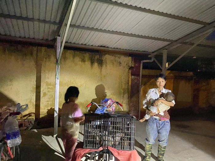 Ba mẹ con chị Chu Thị Hồng Cư khi đang trú mưa bên đường. Ảnh: CA tỉnh Lào Cai.