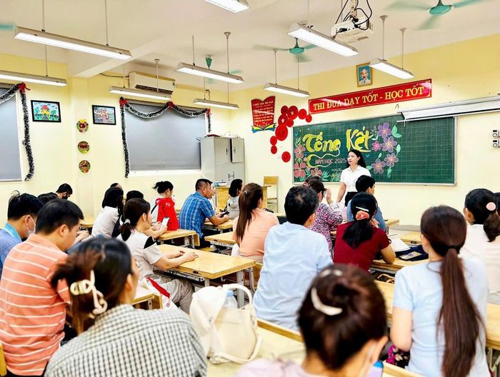 Giáo viên Trường Tiểu học Thị trấn Yên Viên hướng dẫn, hỗ trợ phụ huynh tại phòng học được bố trí làm nơi nghỉ ngơi trong thời gian chờ thí sinh dự Kỳ thi tốt nghiệp THPT năm 2026.