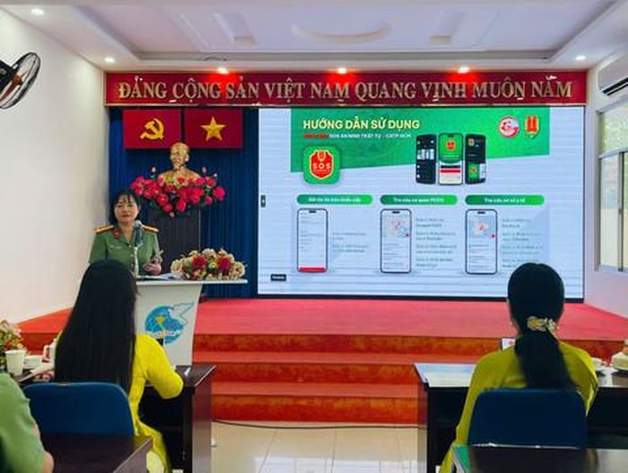 Thượng tá Đỗ Thị Hoàng Anh - Trưởng Ban Phụ nữ Công an TPHCM hướng dẫn các hội viên cài đặt app "SOS An ninh, trật tự" do Công an TPHCM phát triển