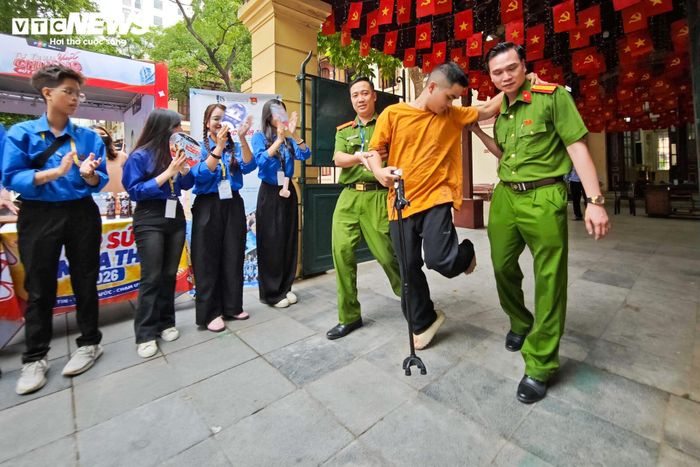 Cán bộ, chiến sĩ Công an TP Hà Nội hỗ trợ một thí sinh bị chấn thương ở chân di chuyển an toàn vào phòng thi.
