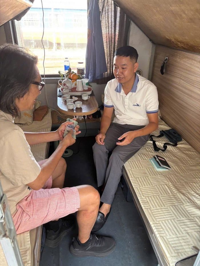 Nhân viên đường sắt trao trả tài sản cho hành khách để quên trên tàu. Ảnh: VNR