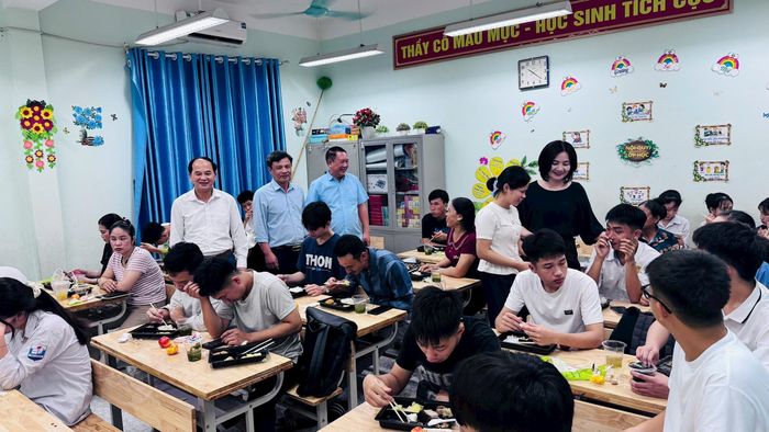 Thí sinh và phụ huynh ăn trưa tại điểm thi Trường THPT Trần Đăng Ninh. Ảnh: Đoàn Thanh