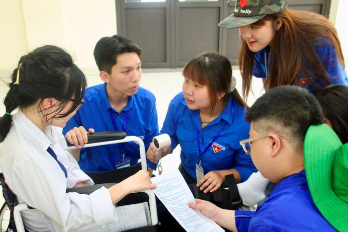 Các tình nguyện viên “Tiếp sức mùa thi” thăm hỏi, động viên em Nguyễn Thanh Bình tại nơi nghỉ do phường Phú Thượng sau khi hoàn thành môn thi Ngữ văn. Ảnh: Cao Kỳ