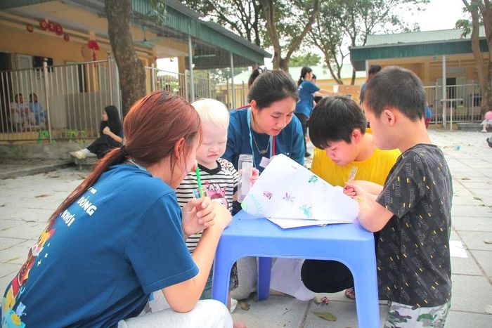 Thành viên dự án Scribbles và các em nhỏ khuyết tật cùng nhau trải qua những khoảnh khắc ấm áp yêu thương. Ảnh: DA.