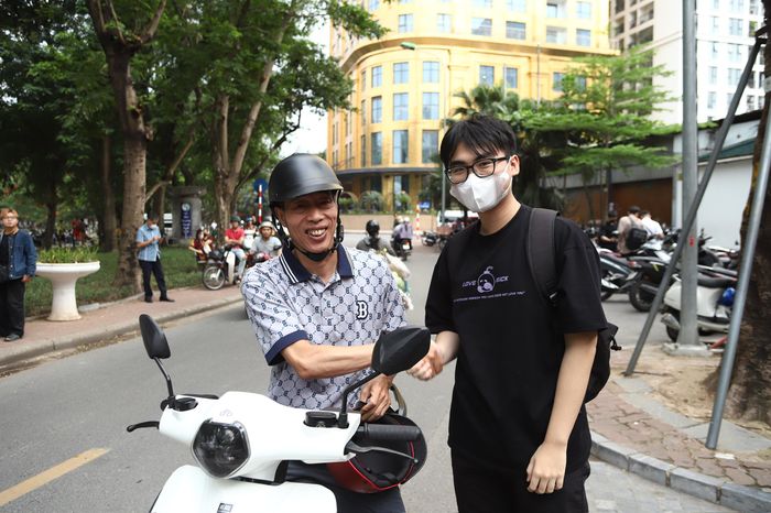 Nụ cười rạng rỡ và cái bắt tay quyết tâm giữa hai cha con trước khi sĩ tử chính thức bước qua cánh cổng trường thi.