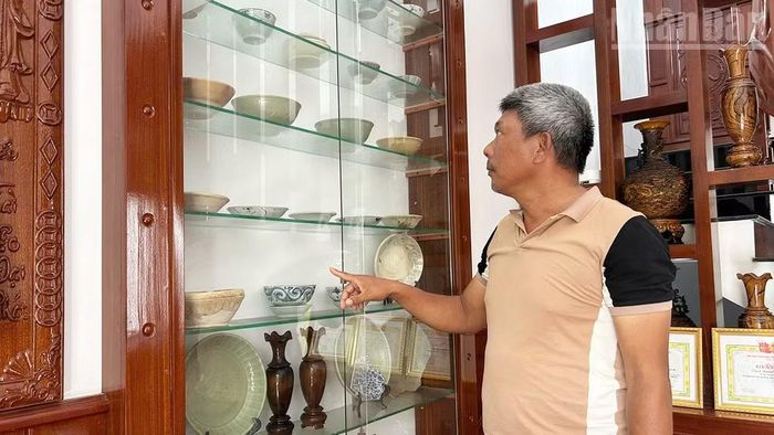 Ngư dân Nguyễn Thuận với tủ trưng bày các cổ vật.