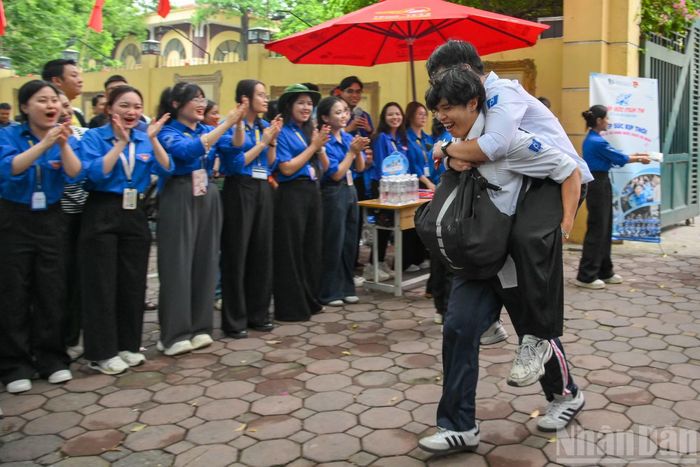 Khoảnh khắc cánh cổng điểm thi hé mở, đôi bạn cùng tiến phấn khởi ùa ra trong lời cổ vũ nhiệt tình từ mọi người chung quanh.