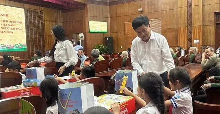 Đồng chí Lê Thành Đô, Chủ tịch Hội đồng nhân dân tỉnh Điện Biên trao quà tặng các cháu học sinh.