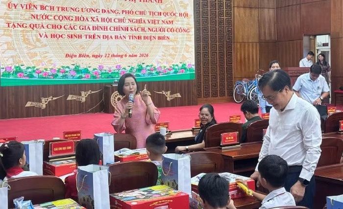 Phó Chủ tịch Quốc hội Nguyễn Thị Thanh trao quà và hướng dẫn các cháu học sinh cách sử dụng bút chấm học tiếng Anh.