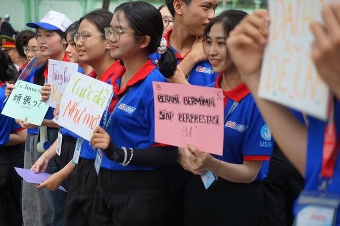 Các đội hình tiếp sức sáng tạo các hoạt động cổ vũ như làm bảng động viên bằng nhiều ngôn ngữ. Ảnh: VÂN NHI