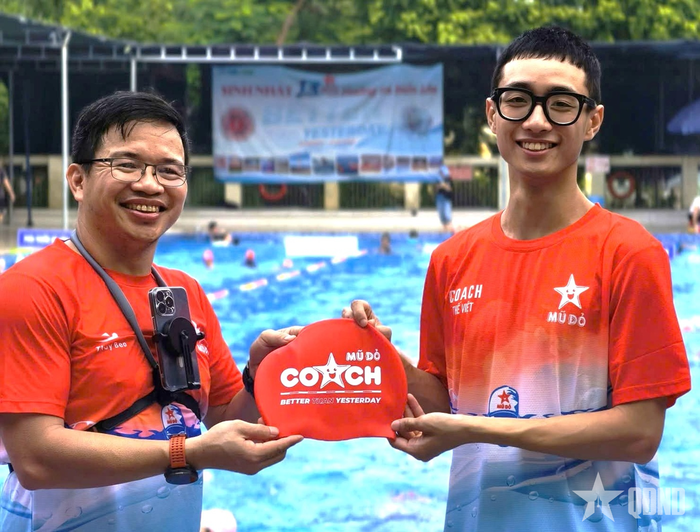 Anh Nguyễn Văn Thủy (trái) trao mũ đỏ cho học viên. 