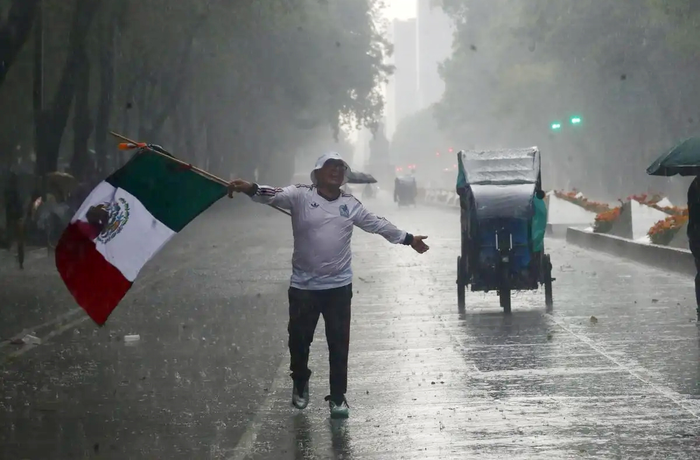 Một người hâm mộ Mexico "tắm mưa" ăn mừng. Ảnh: La Jornada 