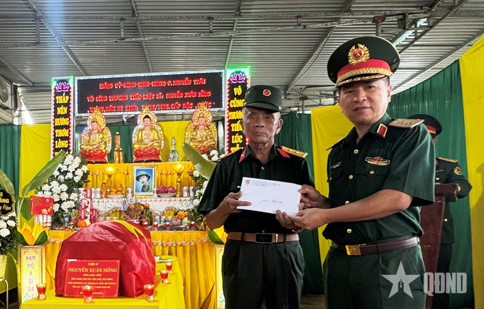 Trung tướng Trần Tấn Hùng, Phó chủ tịch Thường trực Hội Hỗ trợ gia đình liệt sĩ Việt Nam trao phần quà hỗ trợ gia đình ông Trần Đức Huy (người thờ cúng liệt sĩ Nguyễn Xuân Hồng). Ảnh: THÁI GIANG