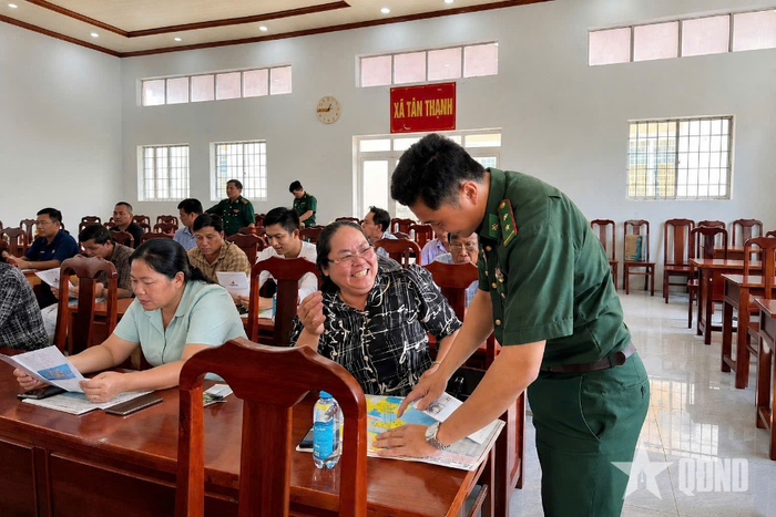  Cán bộ Đồn Biên phòng Xẻo Nhàu (Bộ đội Biên phòng tỉnh An Giang) phát tờ rơi tuyên truyền cho người dân. Ảnh: Hoàng Thiên 