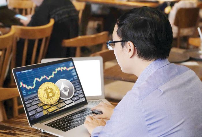  Nhà đầu tư theo dõi diễn biến giá các loại tài sản mã hóa trên một ứng dụng giao dịch. ẢNH: HOÀNG HÙNG 