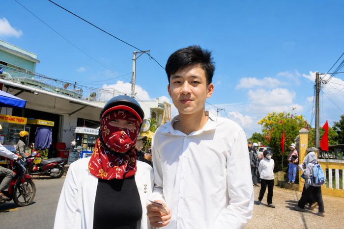 Người mẹ chụp ảnh cùng con trai lưu lại khoảnh khắc kỳ thi tốt nghiệp THPT năm 2026. Ảnh: NGUYỄN TRANG