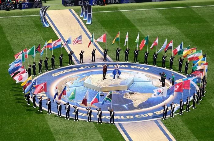 Cờ của 48 đội tuyển dự World Cup 2026 được đưa vào sân, bao quanh sân khấu hình địa cầu trong phần nghi thức khai mạc.